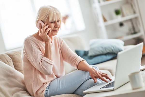 Woman Using Phone And Laptop