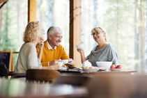 Friends Discussing Funeral Plans Over Tea And Cake