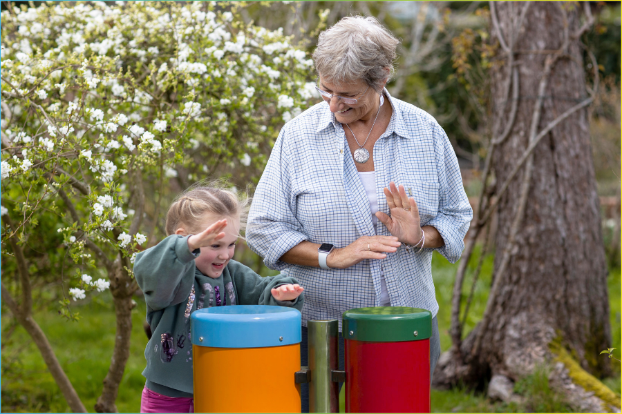 Resident and carer sharing a musical moment using outdoor instruments in a dementia‑friendly garden