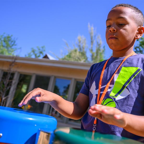 a young boy playing colorful outdoor drums
