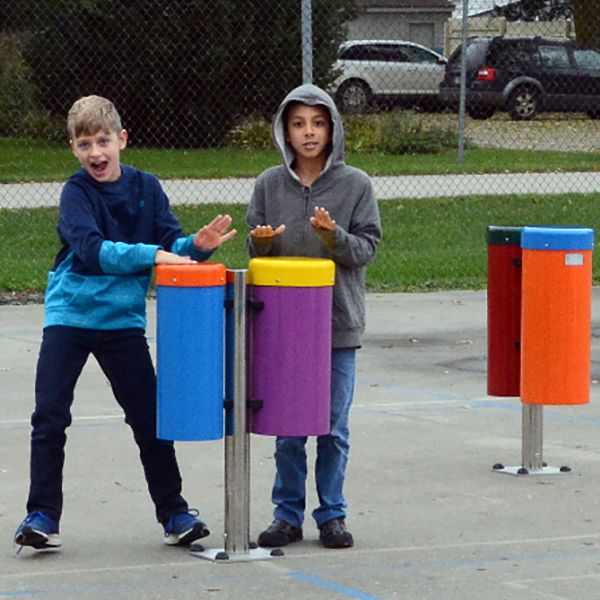 two boys playing on the outdoor playground drums in the musical playground at montezuma elementary school