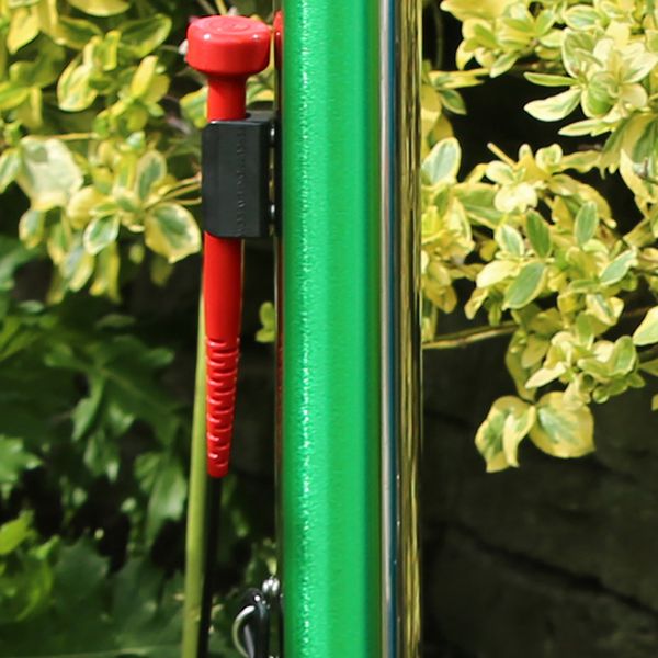 Close up of the green calypso musical chime from percussion play along with its mallet in the mallet minder located on the post