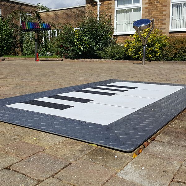 a giant floor piano installed in a playground