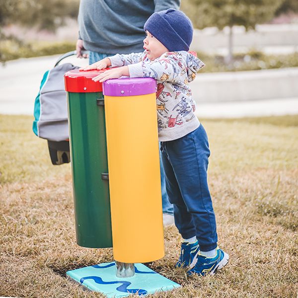 a young boy playing on a pair of outdoor conga drums at the Leonel Castillo Community Center 