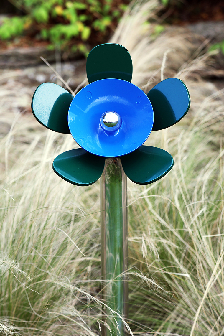 a blue and green musical flower outdoors in a sensory garden