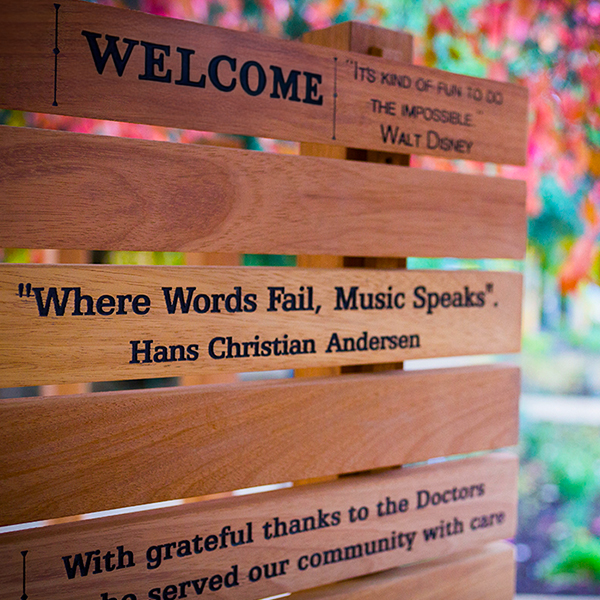 Wooden sign with a Hans Christian Anderson quote engraved 'When words fail, music speaks' 